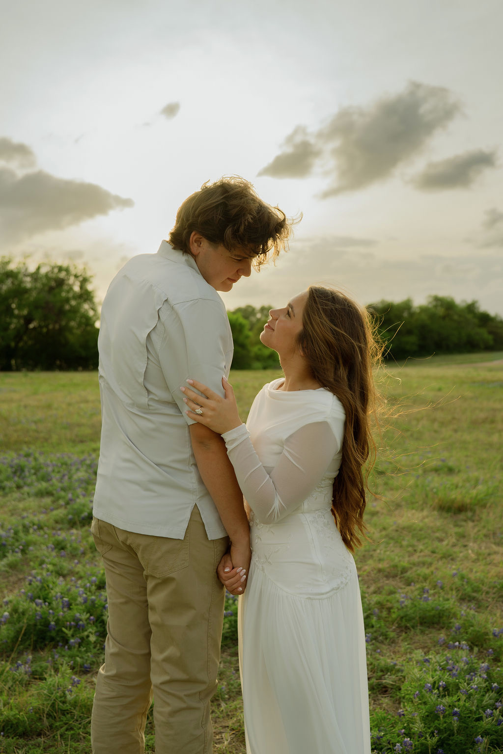 Sam and Rachel in a Texas bluebonnet field at golden hour
